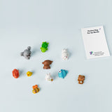 Collection of small toy animals and a note on a white background