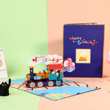 Colorful birthday card with a train design on a pink surface