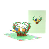 A 3D pop-up greeting card featuring a miniature bouquet with birds and a green background, depicting a romantic theme.