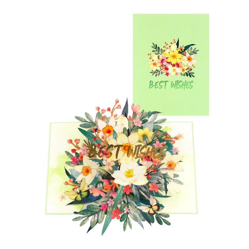 A 3D greeting card with a pop-up lily bouquet design, accompanied by a removable mini bouquet. The card has 'BEST WISHES' text on it.