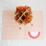 Decorative paper bag with floral design and smiley face on a textured white background