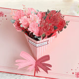 Card with a 3D bouquet of pink and red roses and a pink bow on a light pink background.