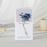 Greeting card with blue flowers and text on a white surface