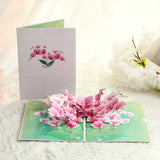 Pop-up card with pink flowers on a white surface