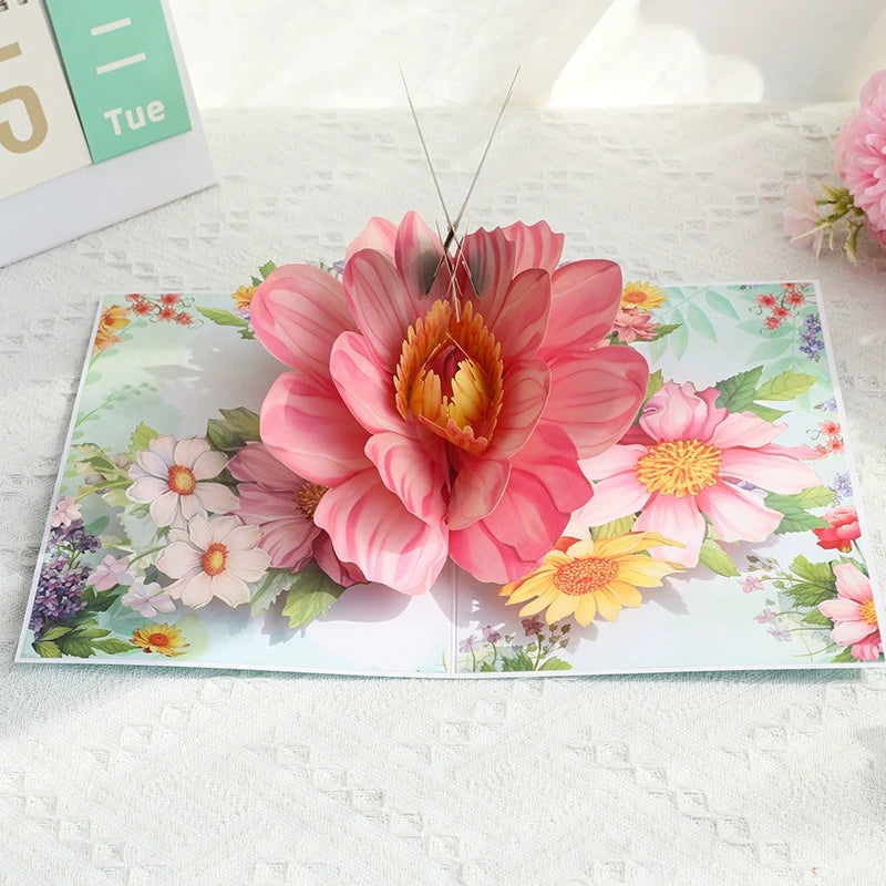 Pop-up card with a pink flower design on a white surface