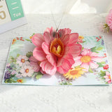 Pop-up card with a pink flower design on a white surface
