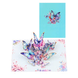 A 3D pop-up greeting card featuring a bouquet of blue butterflies with floral elements, set against a blue background.